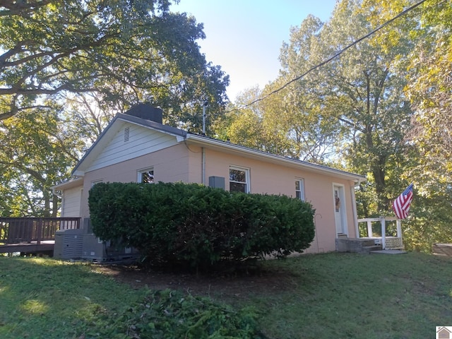 view of side of home with a lawn and a deck