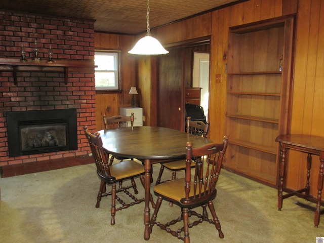 carpeted dining space featuring a brick fireplace and wood walls