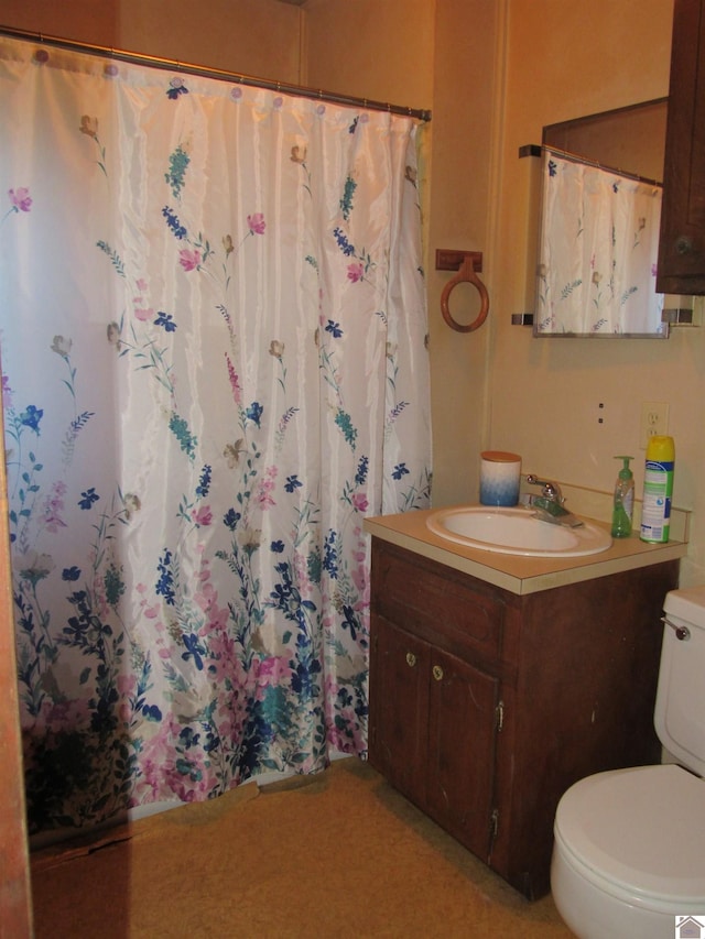 bathroom featuring walk in shower, vanity, and toilet