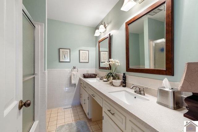 bathroom with vanity, tile patterned flooring, an enclosed shower, and tile walls