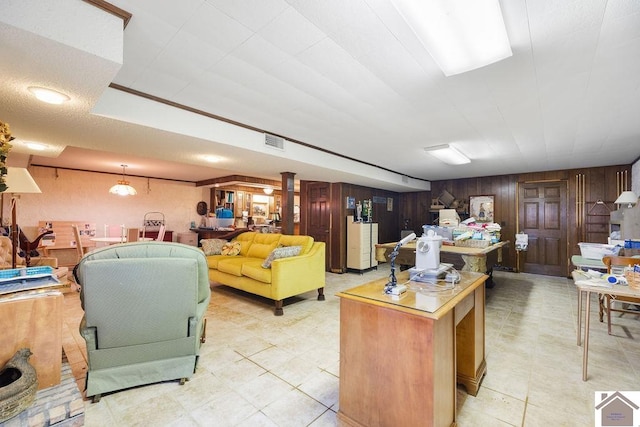 living room featuring light tile patterned floors and wooden walls