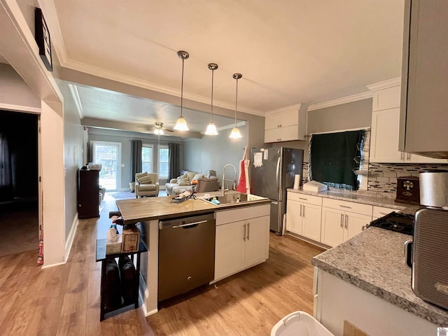 kitchen featuring white cabinets, hanging light fixtures, sink, a kitchen island with sink, and stainless steel appliances