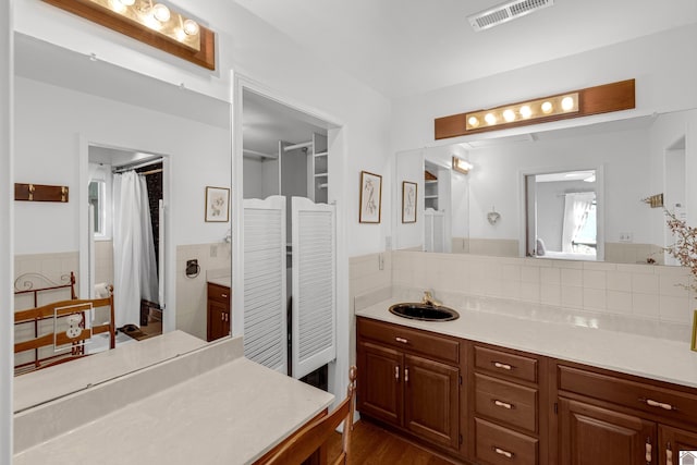 bathroom featuring hardwood / wood-style floors, tile walls, and vanity