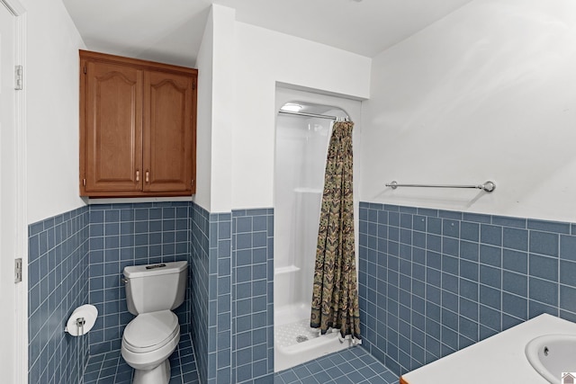 bathroom with tile walls, toilet, and curtained shower