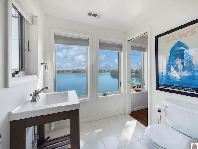 bathroom with a water view, tile patterned floors, vanity, and toilet