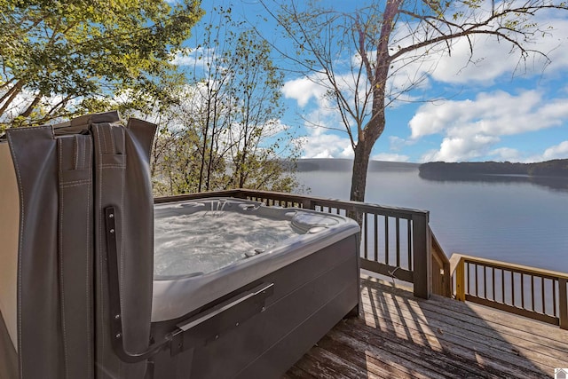 wooden deck featuring a water view and a hot tub