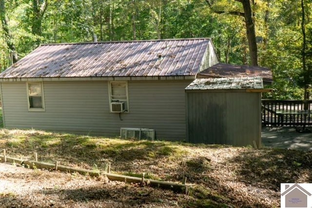 view of side of property with cooling unit and a shed