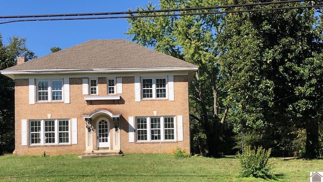 colonial home featuring a front lawn