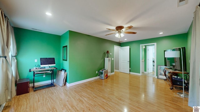 exercise room with ceiling fan and light hardwood / wood-style floors