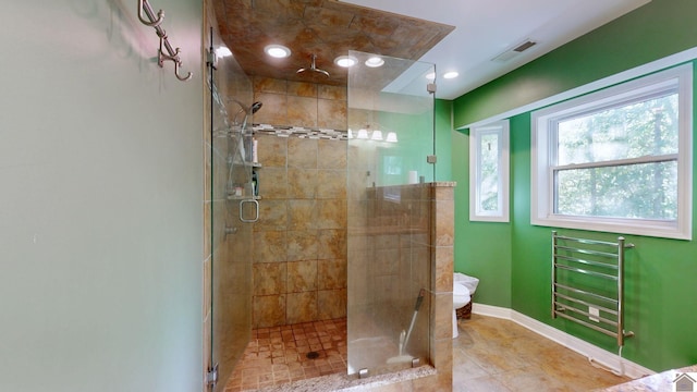 bathroom featuring tile patterned flooring, toilet, and an enclosed shower