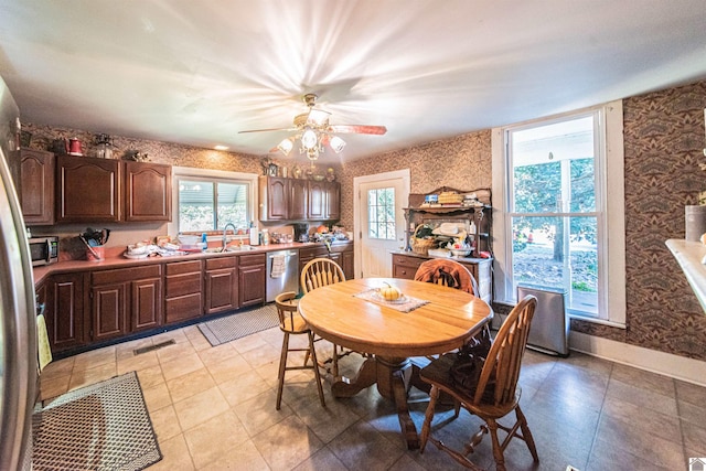 dining room featuring ceiling fan, light tile patterned flooring, and sink