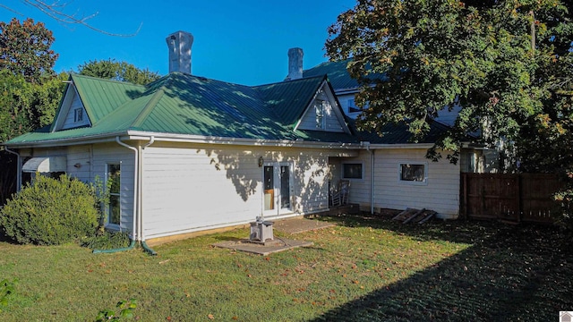 rear view of house featuring a lawn