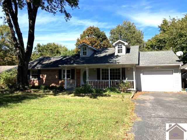 cape cod house with a garage, a front lawn, and a porch