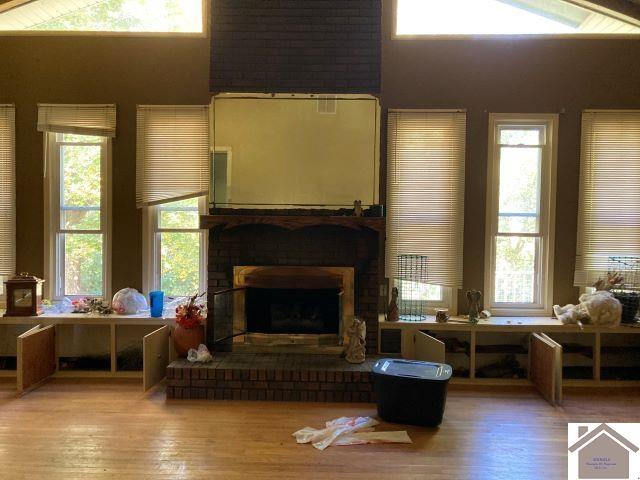 living room featuring a fireplace, high vaulted ceiling, and hardwood / wood-style flooring