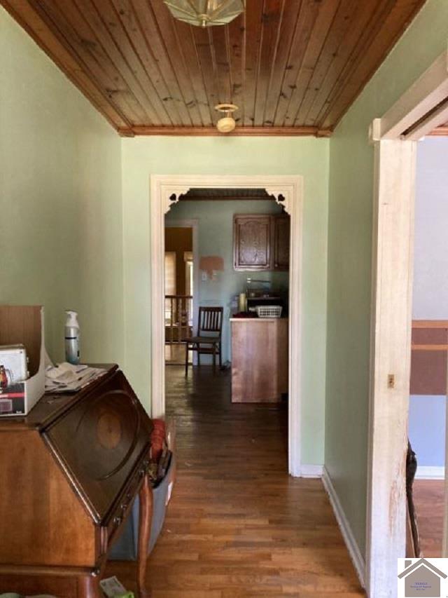 hallway with dark hardwood / wood-style floors and wooden ceiling