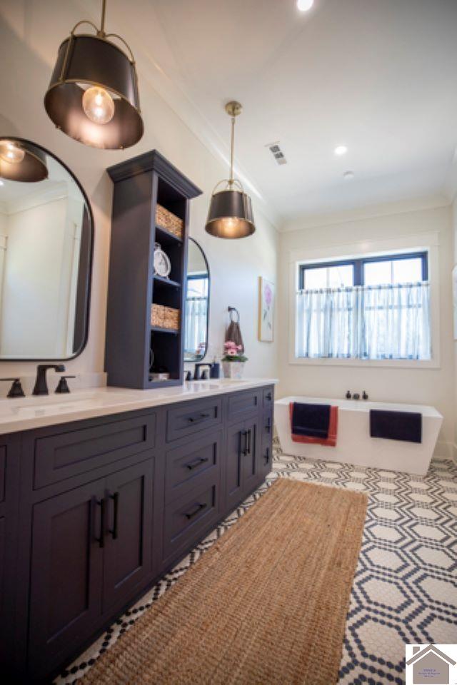 bathroom with a tub to relax in, crown molding, and vanity