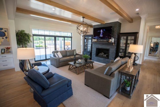 living room featuring a fireplace, a notable chandelier, beam ceiling, and hardwood / wood-style flooring