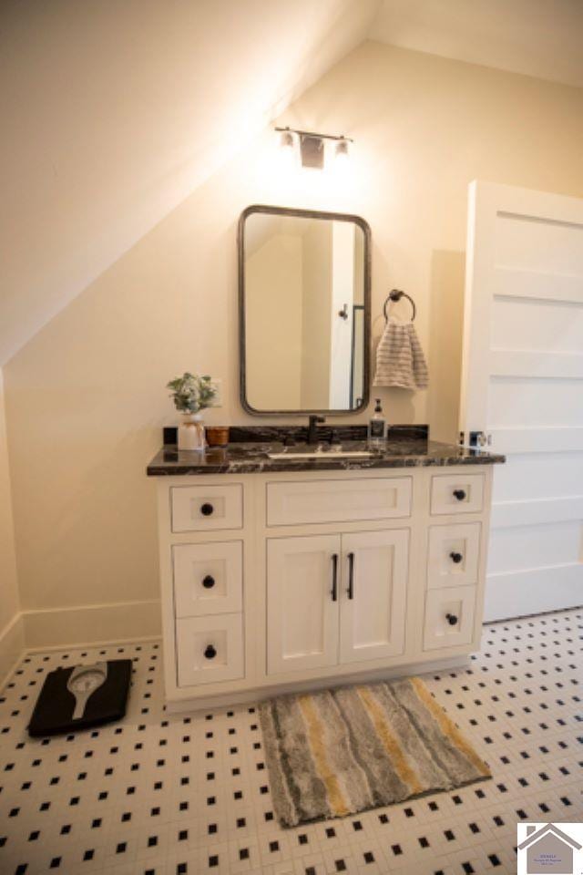 bathroom with vaulted ceiling and vanity