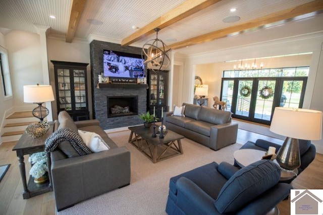 living room with a large fireplace, hardwood / wood-style floors, and beam ceiling