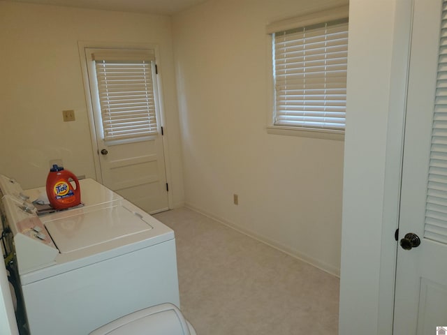 laundry area with washer and clothes dryer and light colored carpet