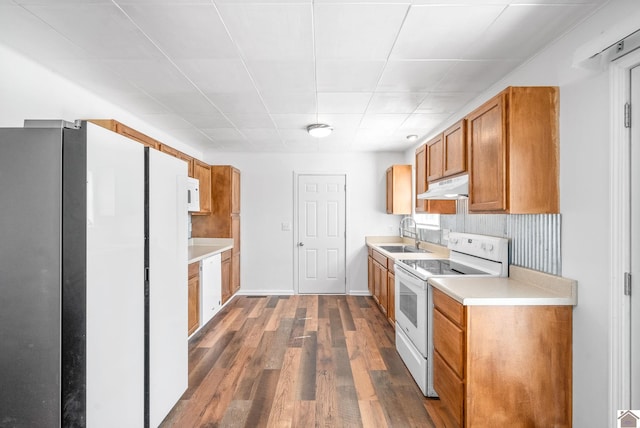 kitchen with sink, backsplash, dark wood-type flooring, and white appliances