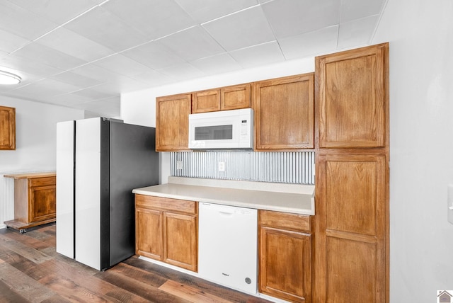 kitchen featuring white appliances and dark hardwood / wood-style floors