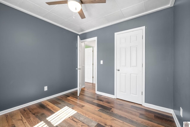 unfurnished bedroom with dark hardwood / wood-style flooring and ceiling fan