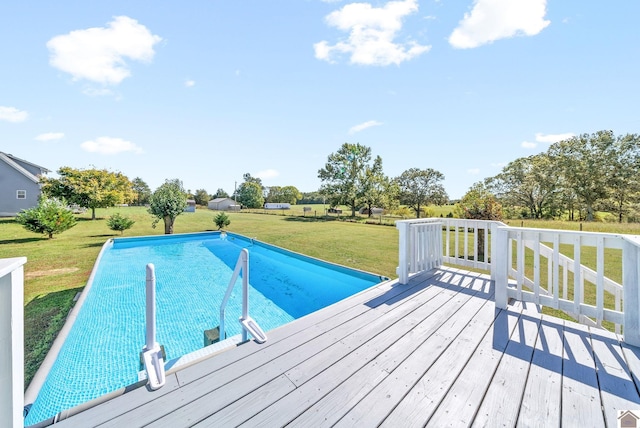 view of pool with a wooden deck and a lawn