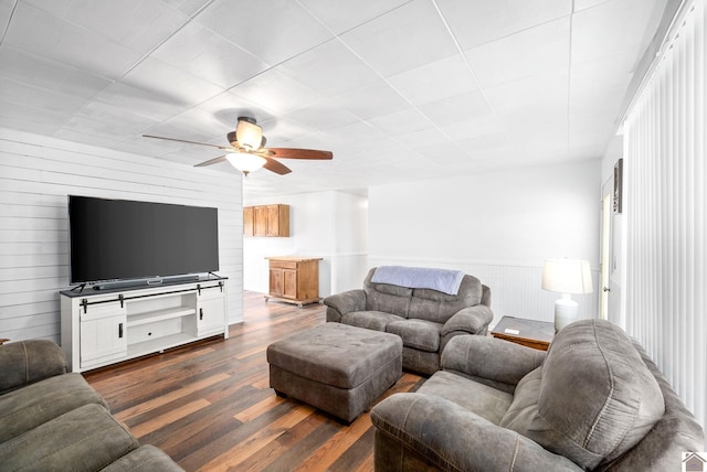 living room with ceiling fan and dark wood-type flooring