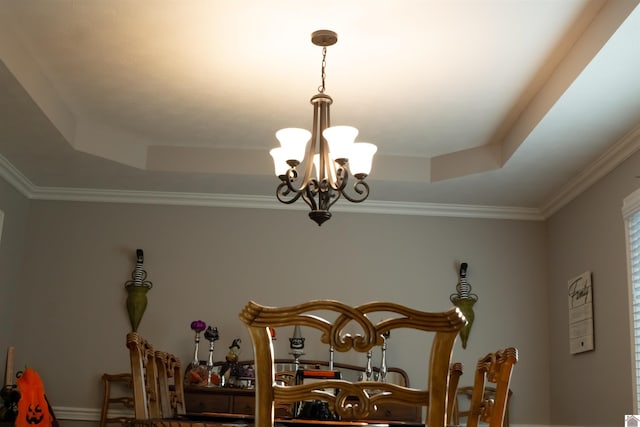 details featuring ornamental molding, a tray ceiling, and a notable chandelier