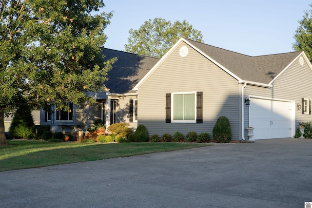 view of front of home with a garage and a front lawn