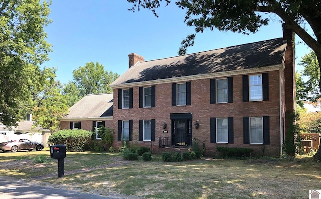 colonial-style house featuring a front yard