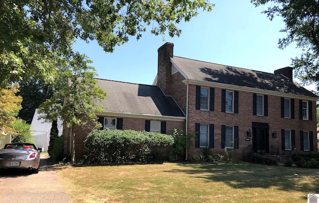 colonial house featuring a front lawn