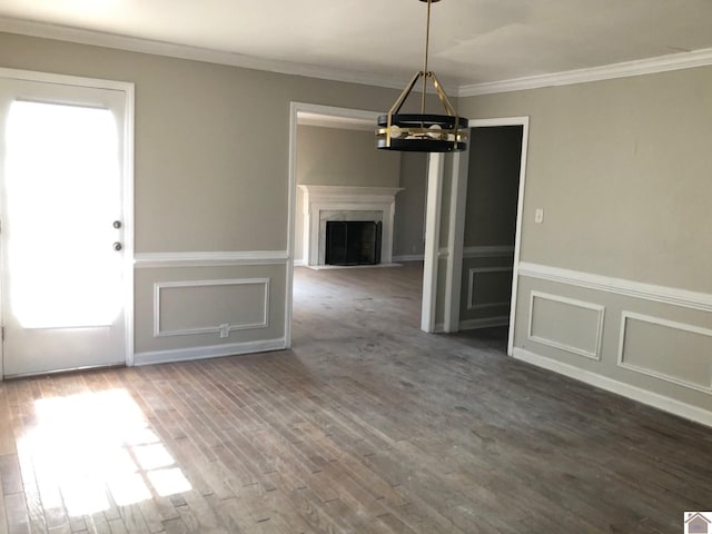 unfurnished dining area featuring crown molding, dark hardwood / wood-style floors, and an inviting chandelier