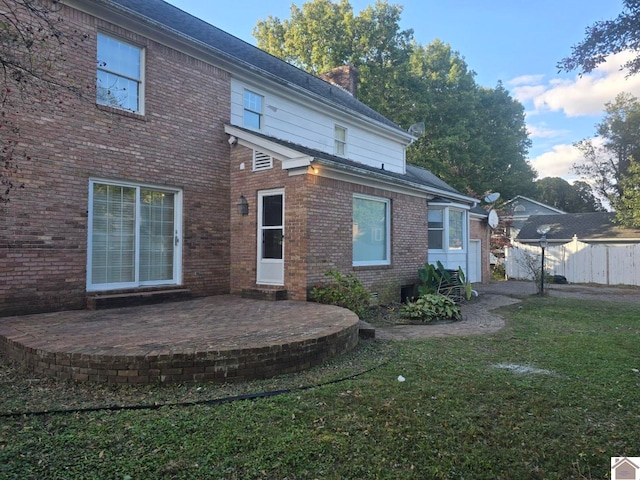 rear view of house with a patio area and a lawn