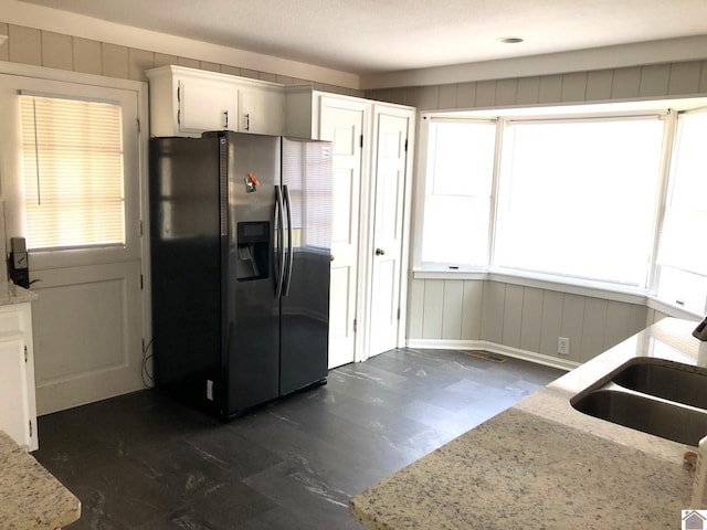 kitchen featuring light stone countertops, sink, dark hardwood / wood-style flooring, white cabinetry, and stainless steel refrigerator with ice dispenser