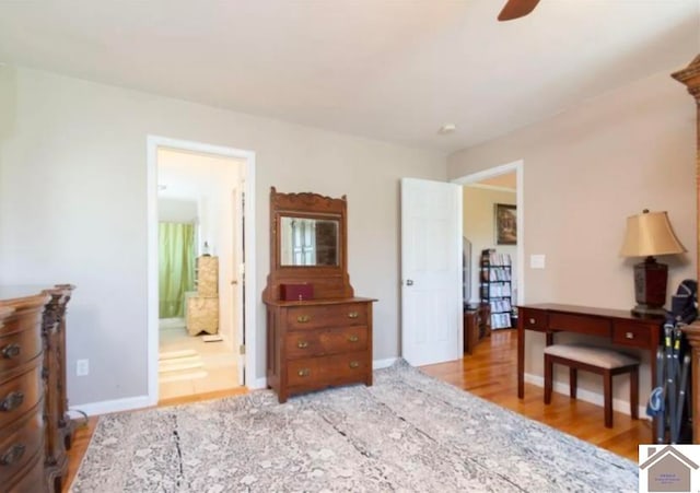 bedroom featuring ceiling fan, light wood-type flooring, and ensuite bath