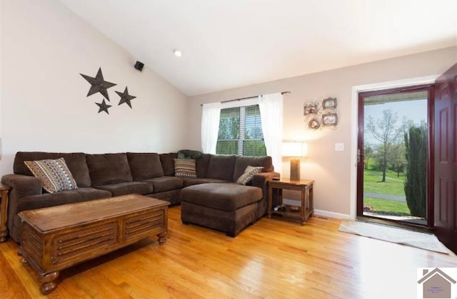 living room featuring lofted ceiling and hardwood / wood-style flooring