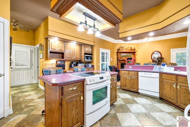 kitchen with ornamental molding, a center island, decorative light fixtures, white appliances, and ceiling fan