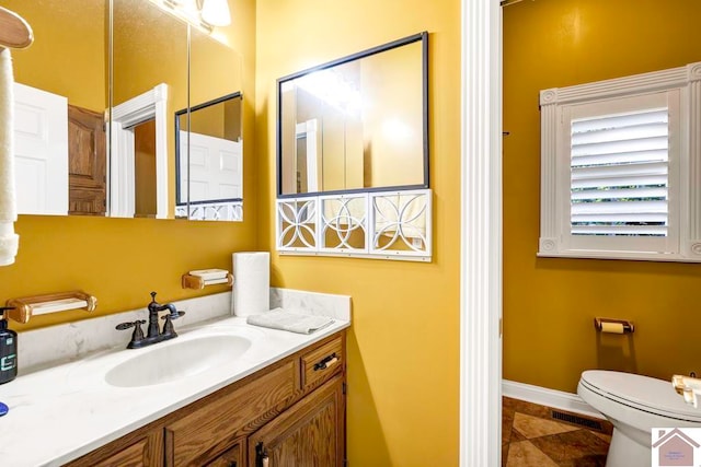 bathroom with vanity, toilet, and tile patterned floors