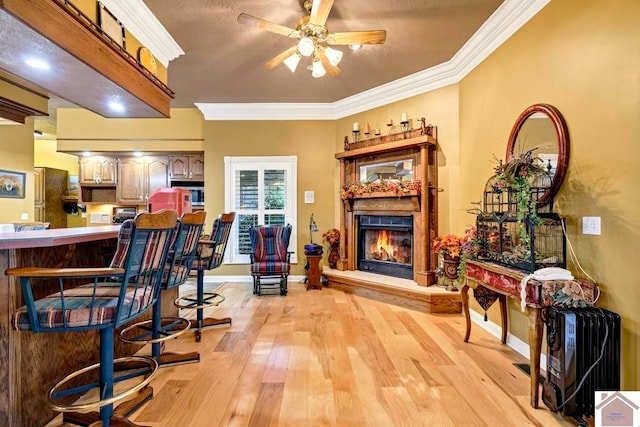 interior space with ornamental molding, light hardwood / wood-style flooring, and ceiling fan