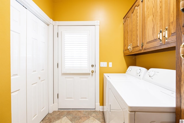 clothes washing area featuring cabinets and independent washer and dryer