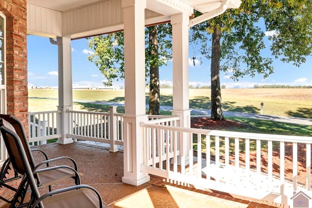 view of patio / terrace with a rural view and covered porch