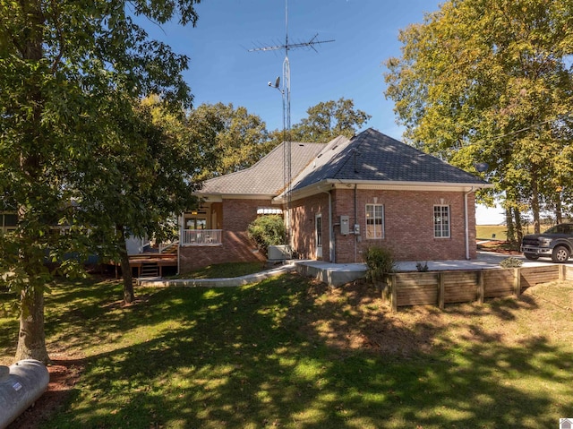 rear view of property featuring a deck and a lawn