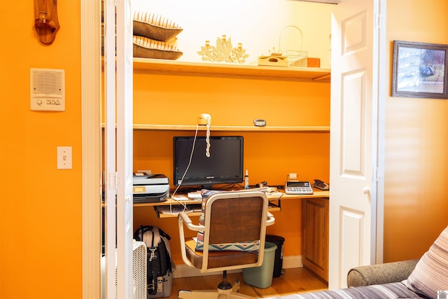 office featuring built in desk and hardwood / wood-style floors