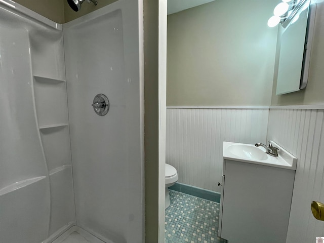 bathroom featuring walk in shower, vanity, toilet, and tile patterned floors