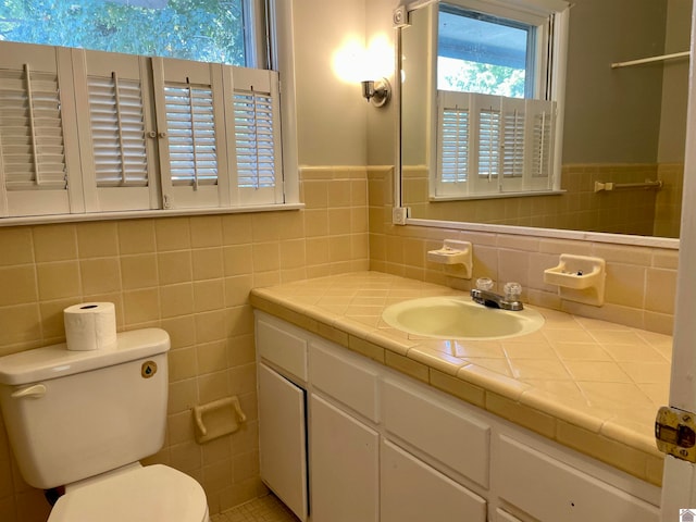 bathroom featuring tile walls, vanity, and toilet