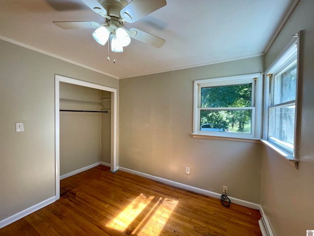 unfurnished bedroom featuring wood-type flooring, a closet, ornamental molding, and ceiling fan