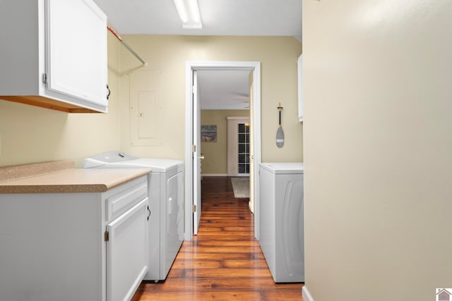 washroom featuring wood-type flooring, cabinets, and separate washer and dryer