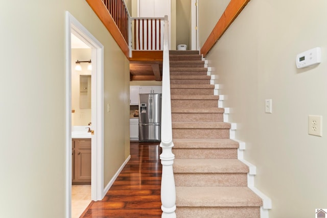 staircase with wood-type flooring and sink